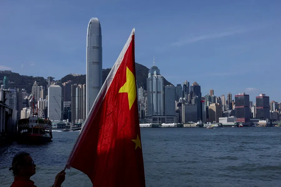 A Chinese supporter waves Chinese national flags to celebrate the 75th anniversary of China’s National Day in Hong Kong, China, on 1 October 2024. (Tyrone Siu/Reuters)