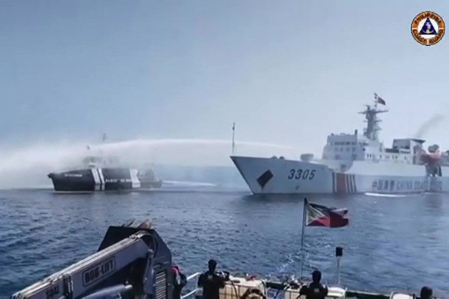 This frame grab taken from video footage released by the Philippine Coast Guard via AFPTV on 9 December 2023 shows a Chinese Coast Guard ship (right) using a water cannon on a Philippine Bureau of Fisheries and Aquatic Resources vessel near Scarborough Shoal in the disputed South China Sea. (Handout/Philippine Coast Guard (PCG)/AFP)