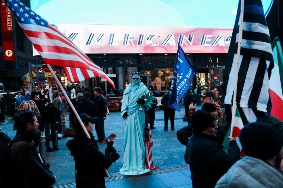 A street performer dressed as the Statue of Liberty in Times Square watches a demonstration against the Iranian government, in Manhattan, New York City, US, on 15 March 2026.
