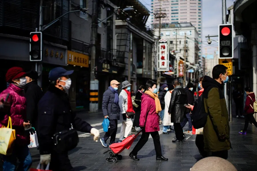 People wearing protective masks visit a main shopping area, following new cases of the coronavirus disease (COVID-19), in Shanghai, China, 21 January 2022. (Aly Song/Reuters)