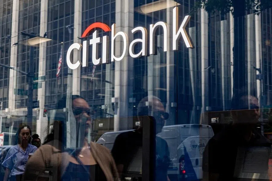 People are reflected in a window as they walk by a Citibank branch in New York City, US, 16 July 2025.
