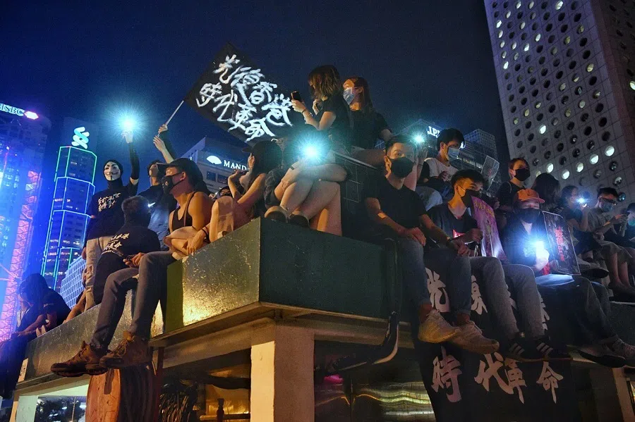 Protesters wave a flag that says "Liberate Hong Kong, revolution of our times" at the roof of a car park next to Edinburgh Place in Hong Kong, China, on 27 September 2019. (SPH Media)