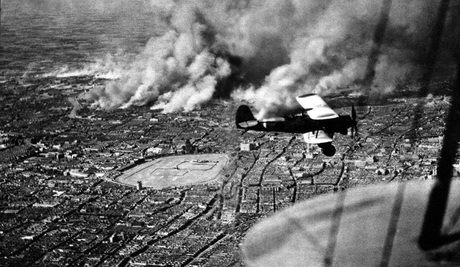 A Japanese military plane flying over Pudong, Shanghai, October 1937. The smoke below is coming from Zhabei which has been bombed by the Japanese. During the Battle of Shanghai, the Japanese deployed many planes to carry out heavy bombing of Shanghai and also Nanjing, Anqing, and Wuhu. The Chinese air force took off from Nanjing and Hangzhou to engage in fierce air battles with the Japanese.