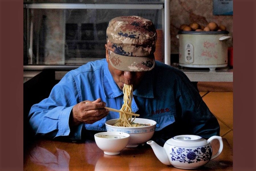 A man eats Lanzhou-style noodles at a restaurant that once served workers of the now decommissioned Liancheng coal-fired power plant in Heqiao village, Yongdeng county, Gansu province, China, 16 September 2020. (Thomas Peter/Reuters)
