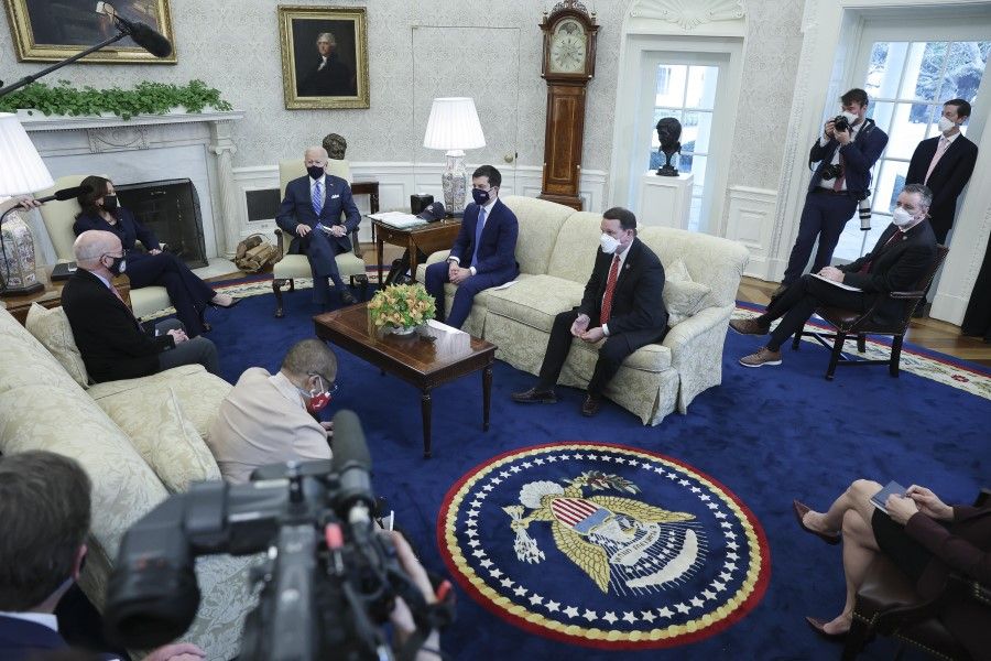 US President Joe Biden (centre left) wears a protective mask while speaking during a meeting with House members in the Oval Office of the White House in Washington DC, US, on 4 March 2021.(Oliver Contreras/Bloomberg)