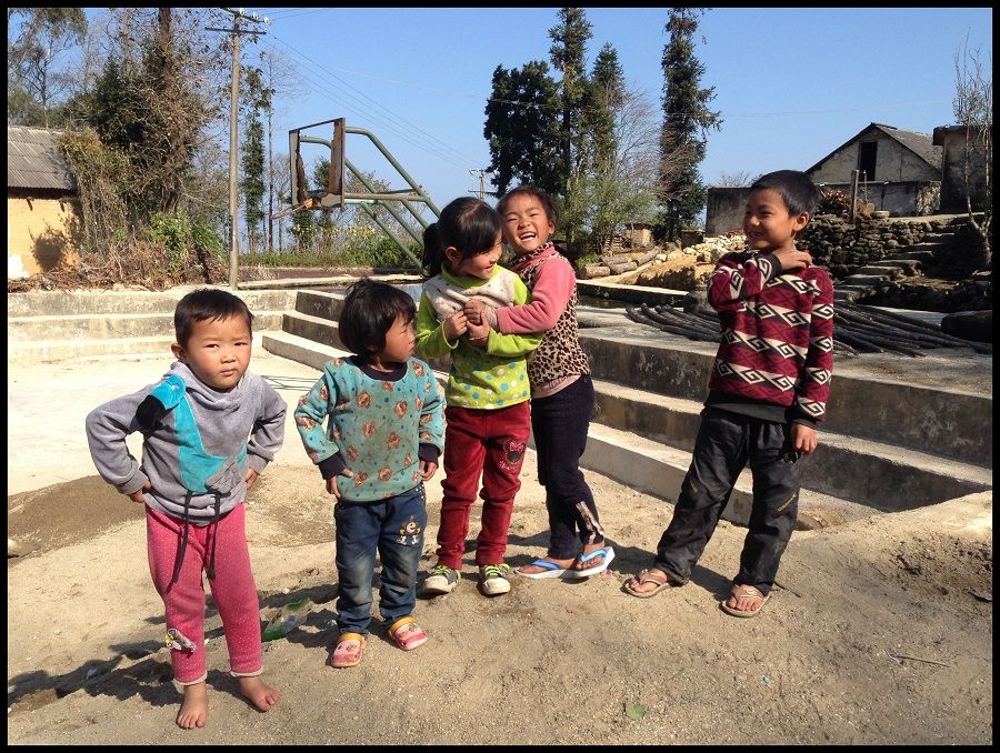Children in rural Yunnan enjoying a moment in the sun. With conditions less than ideal, many youth migrate to cities in search of better fortunes.