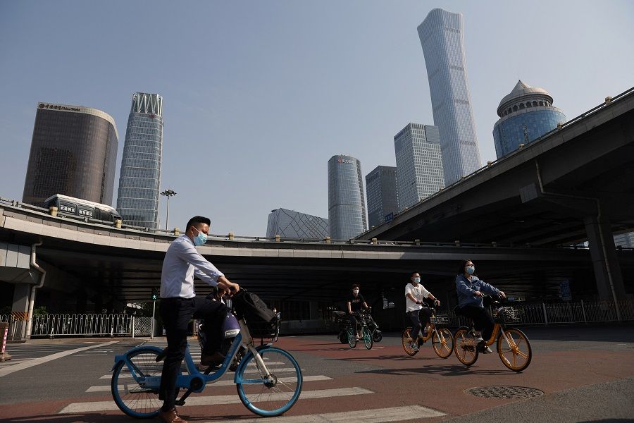 People ride shared bicycles during morning rush hour at the central business district in Beijing, China, 5 May 2022. (Tingshu Wang/Reuters)
