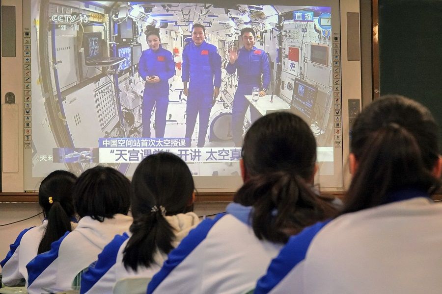 Students watch a live image of a lesson by Chinese astronauts from China's Tiangong space station, at a school in Yantai, Shandong province, China, on 9 December 2021. (AFP)