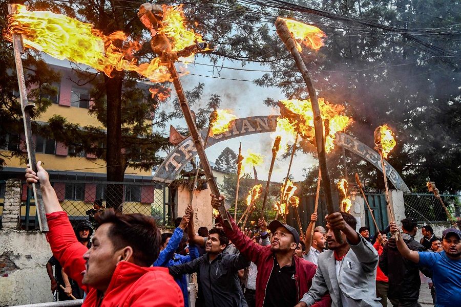Student activists hold torches and shout slogans during a protest over hike in fuel prices in Kathmandu, Nepal, on 20 June 2022. (Prakash Mathema/AFP)