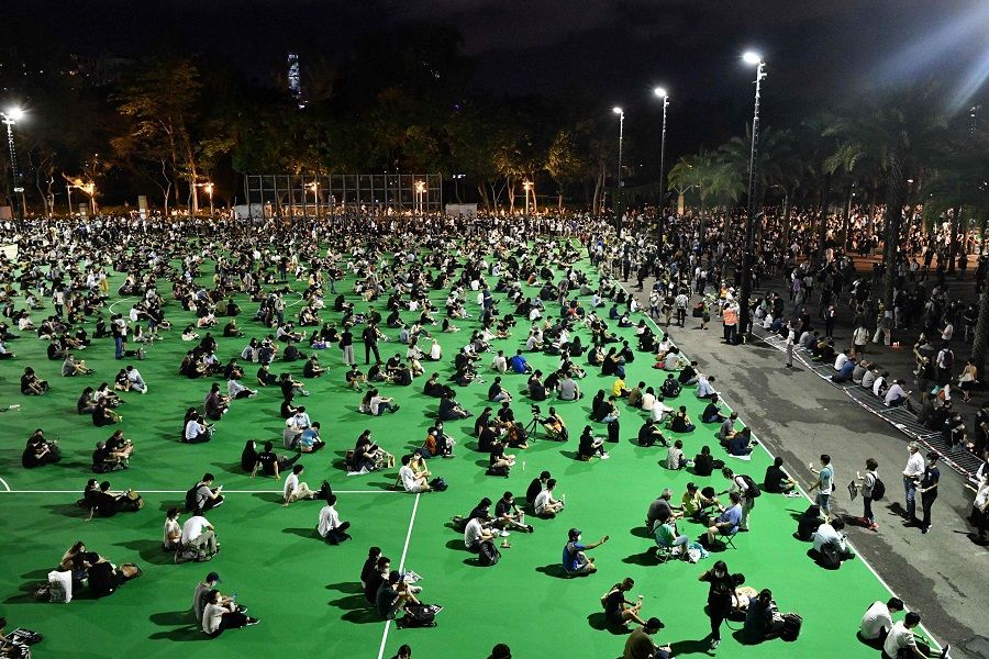 This file photo taken on 4 June 2020 shows activists holding a candlelight remembrance in Victoria Park in Hong Kong, after an annual vigil that traditionally takes place in the park to mark the 1989 Tiananmen Square crackdown was banned on public health grounds because of the Covid-19 coronavirus pandemic. (Anthony Wallace/AFP)