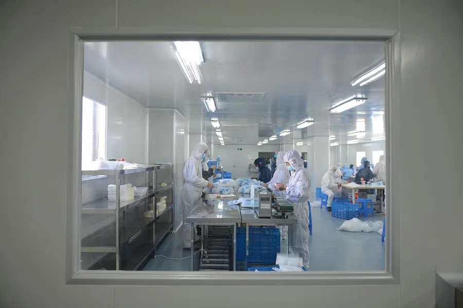 This photo taken on 18 February 2020 shows workers making face masks to satisfy increased demand during China's Covid-19 outbreak, at a factory in Nanjing, Jiangsu, China. (STR/AFP)