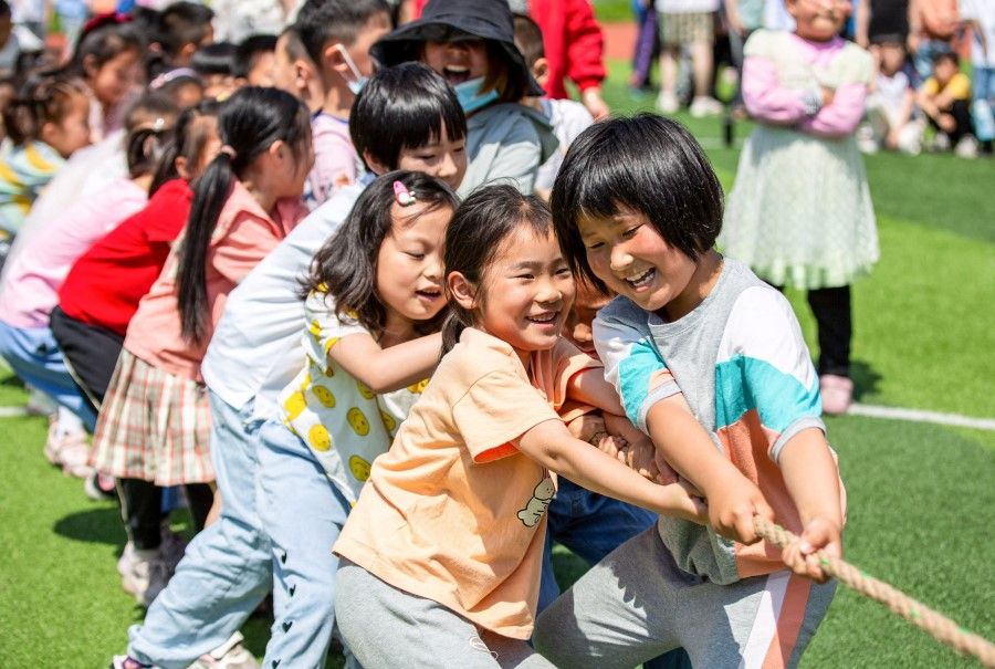 Elementary school students play on International Children's Day in Hai'an in China's eastern Jiangsu province on 1 June 2021, a day after China announced it would allow couples to have three children. (STR/AFP)