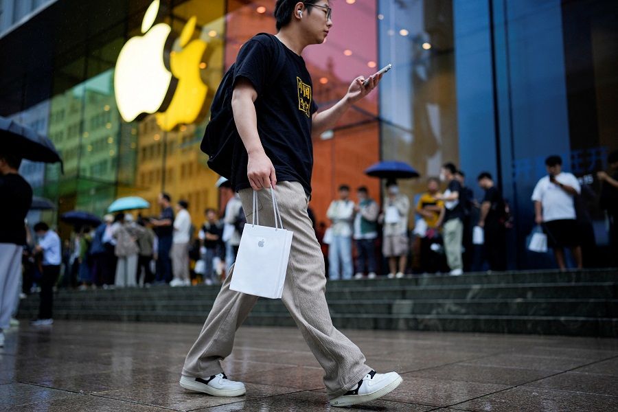 A man holds an Apple bag in Shanghai, China, on 22 September 2023. (Aly Song/Reuters)
