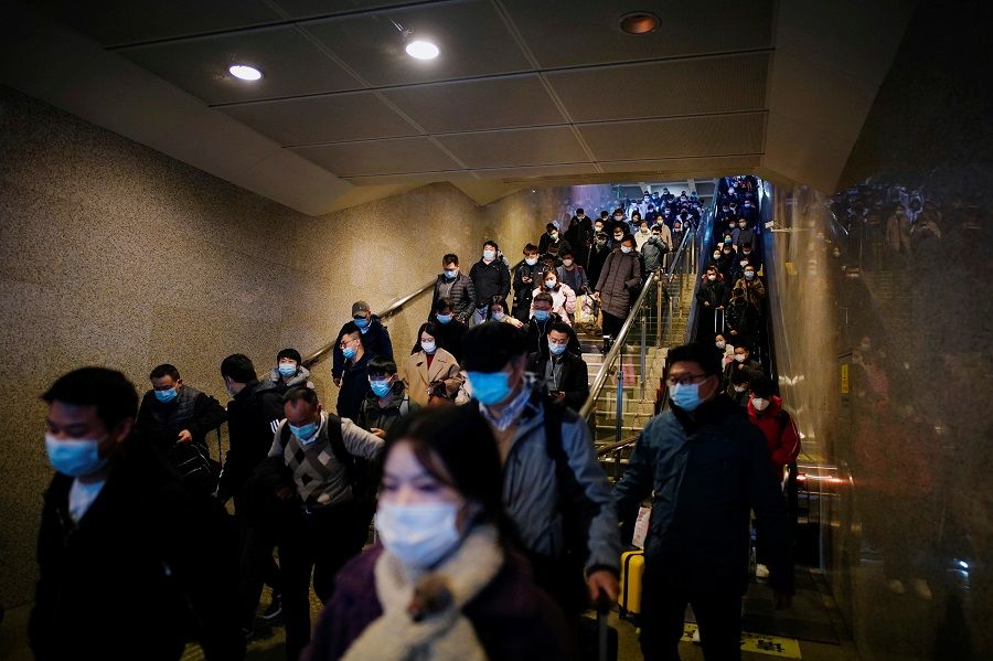 People wearing face masks arrive at a railway station in Wuhan, Hubei province, China, 6 December 2020. (Aly Song/Reuters)