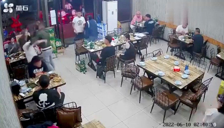 A man assaults a woman at a restaurant in the city of Tangshan, China, 10 June 2022, in this screen grab taken from surveillance footage obtained by Reuters on 12 June 2022. (Video obtained by Reuters)