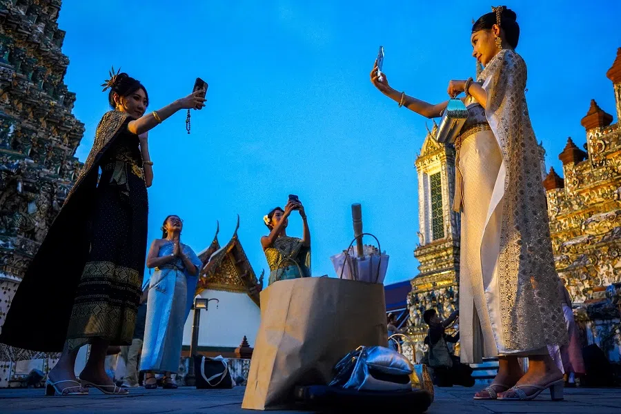 Tourists from China dressed in traditional Thai costumes pose as they visit Wat Arun, known as the Temple of Dawn, in Bangkok, Thailand, on 21 November 2024.