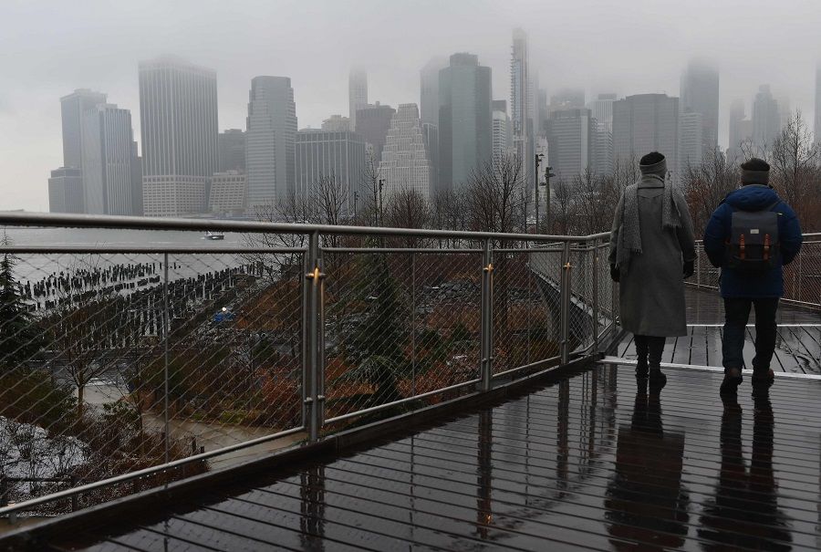 People walk in the Brooklyn borough after a winter storm brought snow and rain on 26 January 2021 in New York City, US. (Angela Weiss/AFP)