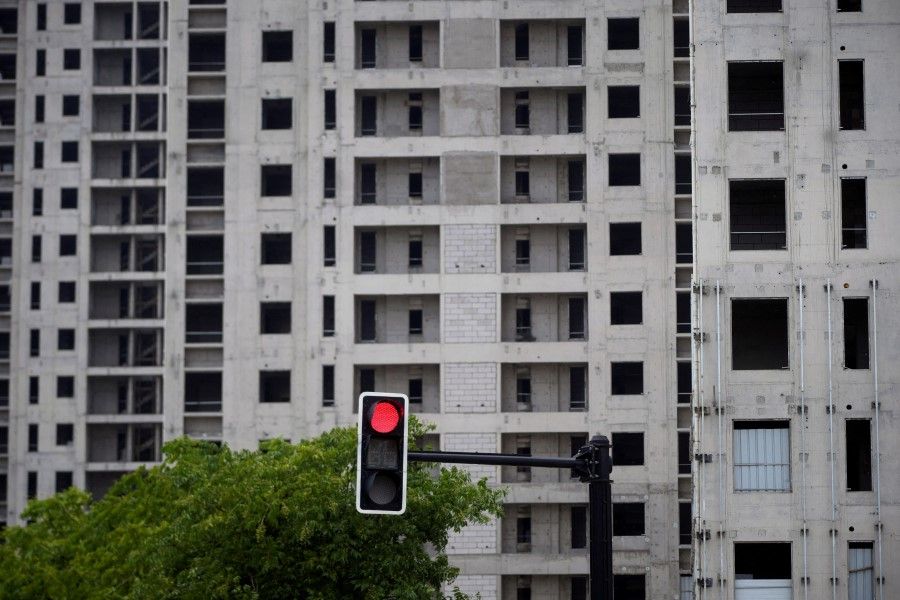 A traffic light is seen near a construction site of residential buildings in Shanghai, China, 20 July 2022. (Aly Song/Reuters)
