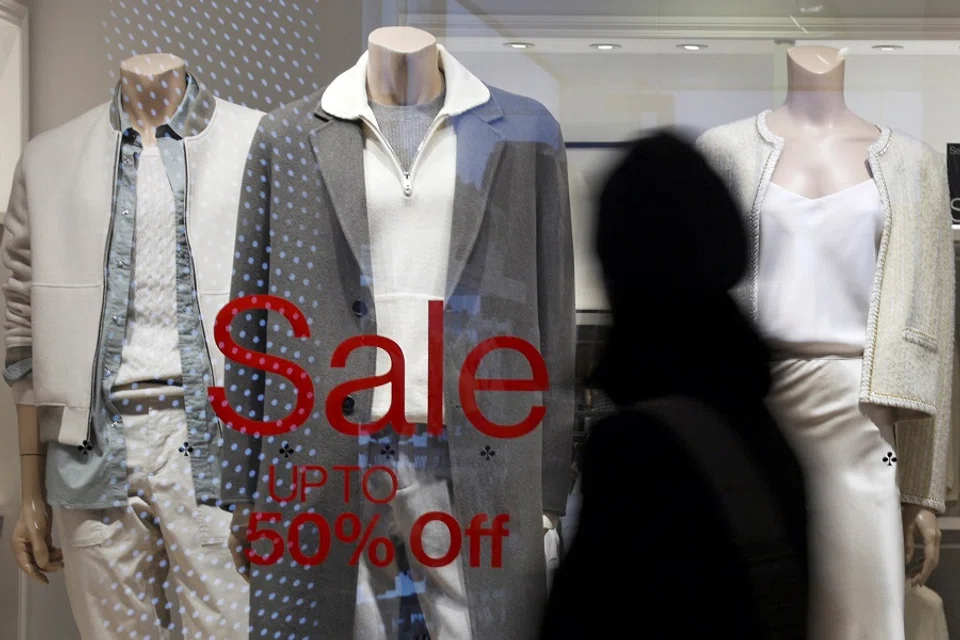 Mannequins stand behind a shop window with a sale sign, at a clothing store inside a shopping complex in Beijing, China, on 4 January 2024. (Florence Lo/Reuters)