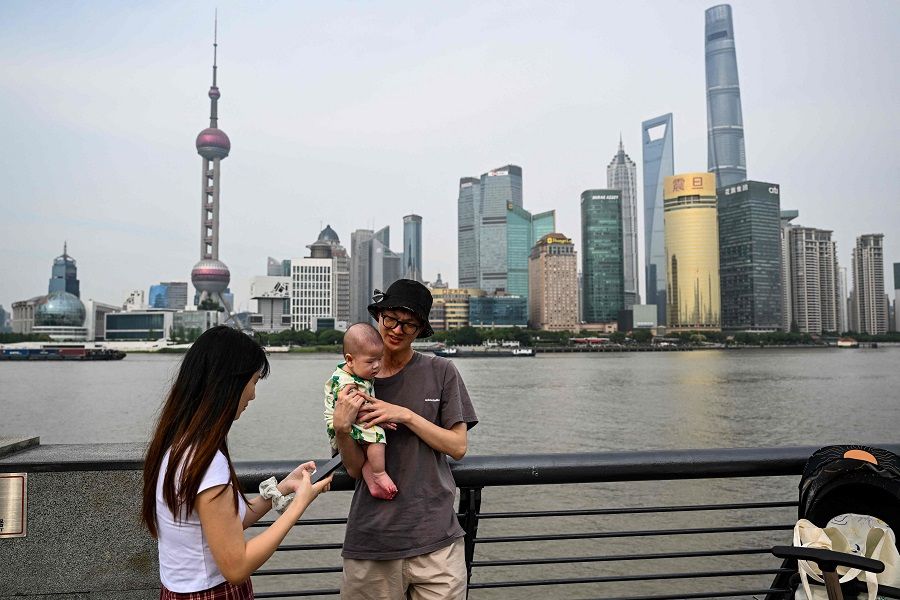 A couple visits the Bund promenade along the Huangpu river in the Huangpu district in Shanghai, China, on 15 June 2023. (Hector Retamal/AFP)