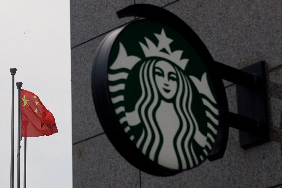 The Chinese flag flies near the Starbucks logo outside a cafe of the coffee chain in Beijing, China, on 3 August 2022. (Thomas Peter/Reuters)