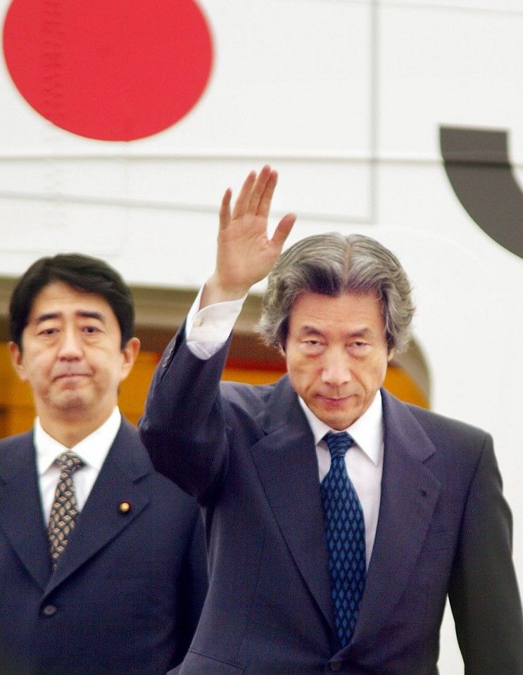 This file photo taken on 17 September 2002 shows Japanese Prime Minister Junichiro Koizumi, accompanied by then-Vice Cabinet Secretary Shinzo Abe (left), waving to well-wishers as he leaves Tokyo International Airport for Pyongyang to meet with then-North Korean leader Kim Jong Il. (Yoshikazu Tsuno/AFP)