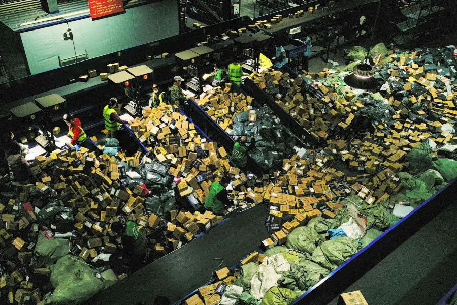 Workers sort packages at a logistics company in Hengyang in China's central Hunan province on 12 November 2021, a day after "Singles' Day", the biggest shopping day of the year. (AFP)