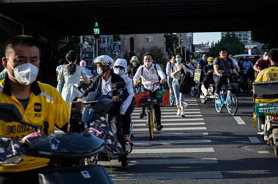 People cross a road during rush hour in Beijing, China, on 2 June 2022. (Jade Gao/AFP)