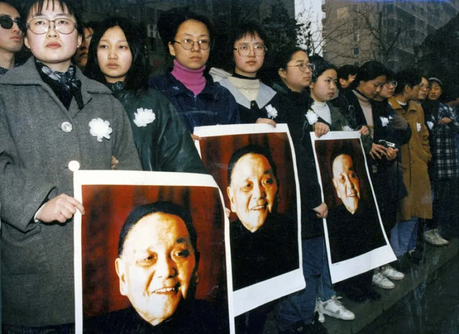 Students at Peking University stand solemnly on the roadside as the funeral procession for Deng Xiaoping passes by, February 1997.