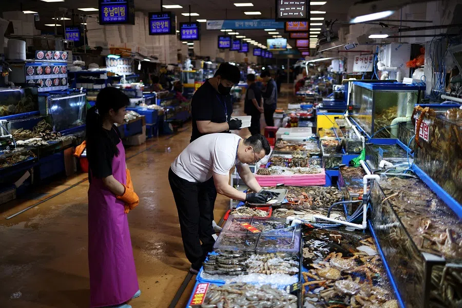 An official measures radiation levels of scallops imported from Japan as they conduct a radioactivity check, which has been conducted regularly since the 2011 Fukushima disaster, at Noryangjin fisheries wholesale market in Seoul, South Korea, 6 July 2023. (Kim Hong-Ji/Reuters)