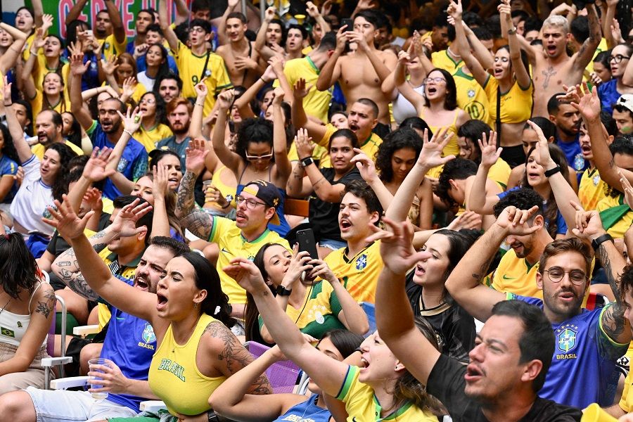 Fans of Brazil react while watching the broadcast of the Qatar 2022 World Cup Group G football match between Brazil and Serbia at a bar in Brasilia, Brazil, on 24 November 2022. (Evaristo Sa/AFP)