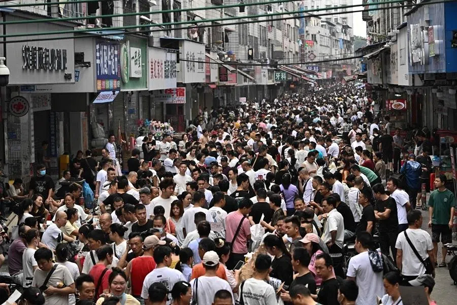 This picture taken on 27 April 2026 shows job-seeking labourers and recruiters from clothing factories on a street in an urban village in Guangzhou, in southern China's Guangdong province. (Pedro Pardo/AFP)