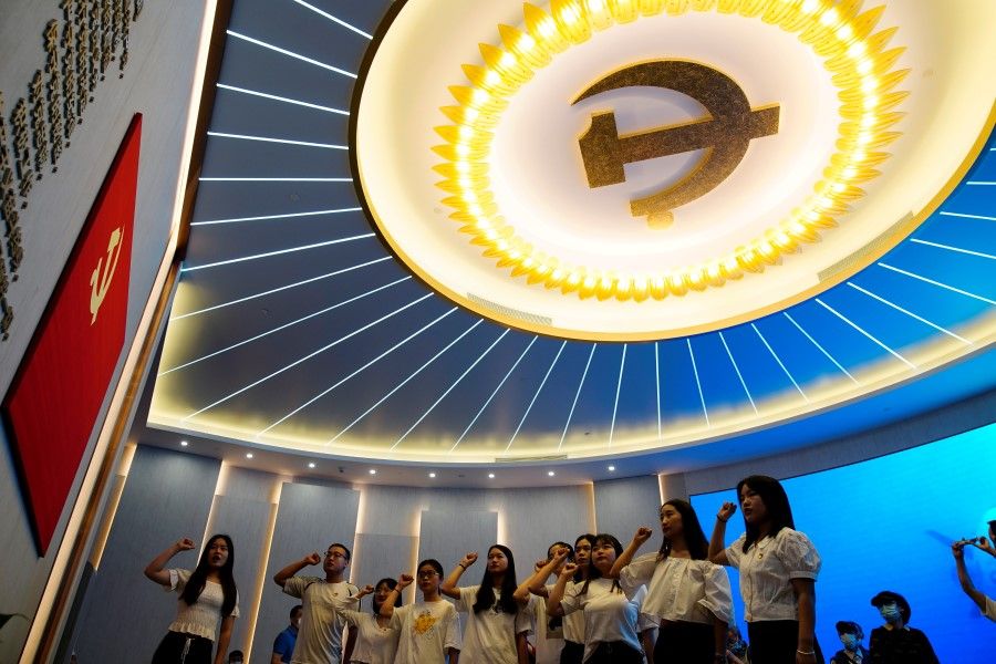 Young people recite the party's oath in front of a party flag during an exhibition at the Memorial of the First National Congress of the Communist Party of China, ahead of the 100th founding anniversary of the party, in Shanghai, China, 4 June 2021. (Aly Song/Reuters)
