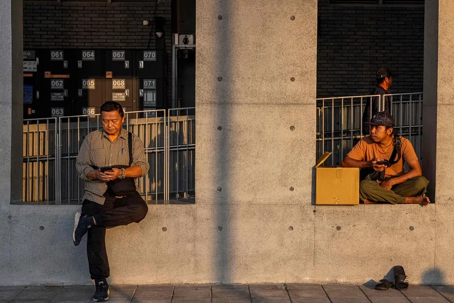 People sit outside of the Nangan Fuao Harbour on Nangan island in Taiwan's Matsu Islands on 13 October 2023. (Annabelle Chih/AFP)