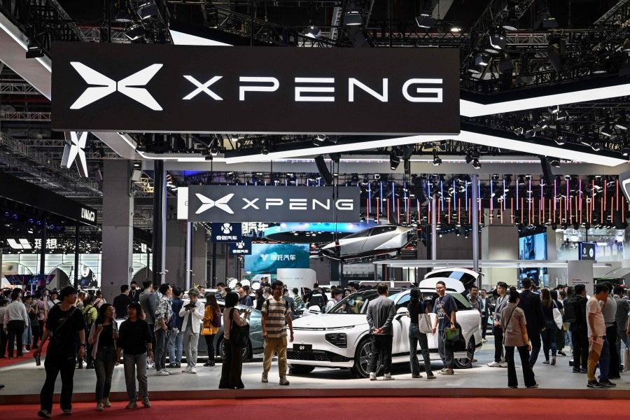 People visit the Xpeng booth during the 20th Shanghai International Automobile Industry Exhibition in Shanghai on 19 April 2023. (Hector Retamal/AFP)