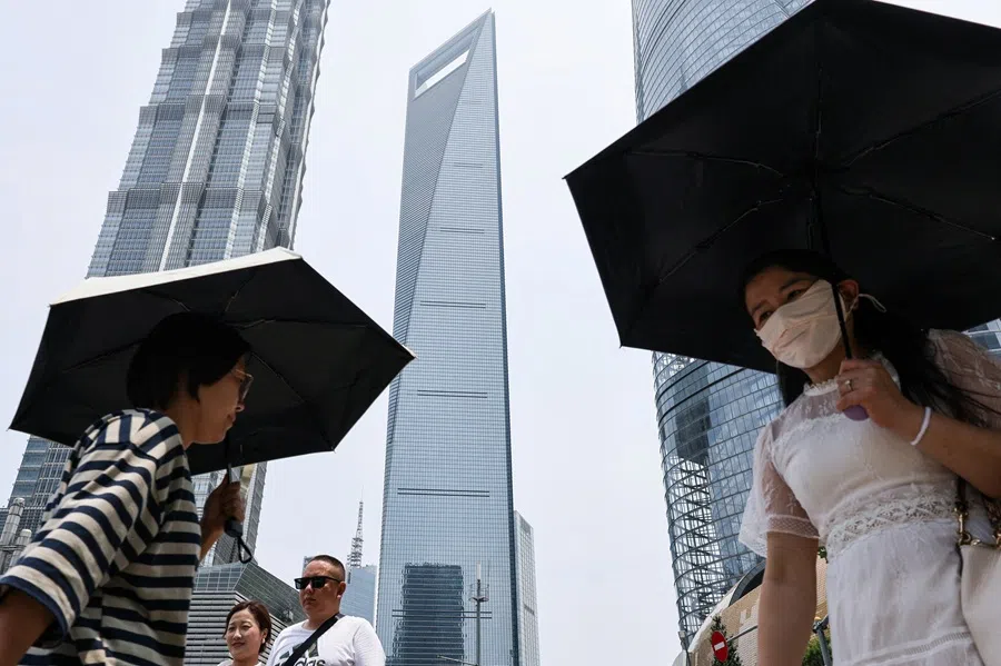 People walk in the Lujiazui financial district in Shanghai, China, on 18 July 2025. (Go Nakamura/Reuters)