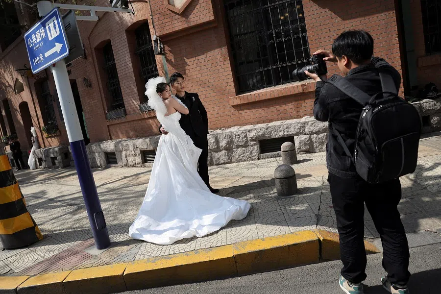 A couple poses for a pre-wedding photoshoot in Qingdao, Shandong province, China on 21 April 2024. (Florence Lo/Reuters)
