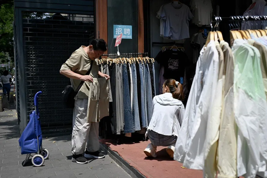 A man at a clothing shop along a road in Bejiing on 11 June 2025. (Wang Zhao/AFP)