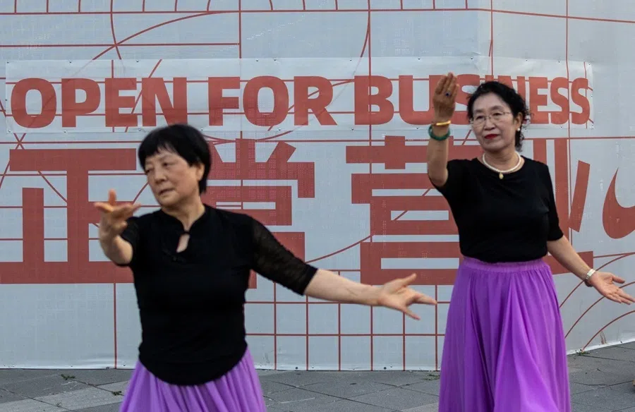 Elderly women dance next to a building facade on Wangfujing Street in Beijing, China, on July 8, 2026.