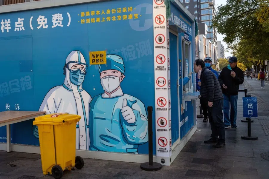 Residents at a Covid-19 testing booth in Beijing, China, on 14 November 2022. A surge in Covid cases threatens to turn into an early test of China's resolve to ease some of its strict virus controls, after health officials on the weekend said the changes were a refinement, not a relaxation, of the rules. (Bloomberg)