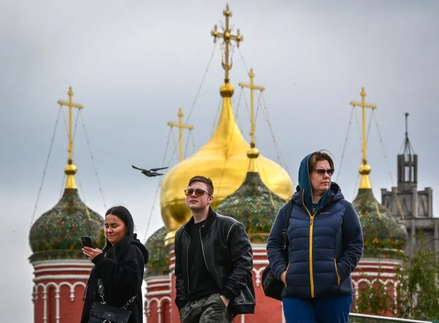 People walk near a cathedral at the Zaryadye park in Moscow on 24 May 2022. (Yuri Kadobnov/AFP)