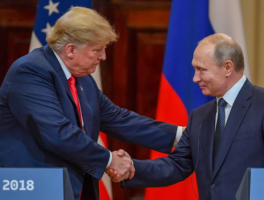 US President Donald Trump (left) and Russian President Vladimir Putin shake hands before attending a joint press conference after a meeting at the Presidential Palace in Helsinki on 16 July 2018. (Yuri Kadobnov/AFP)