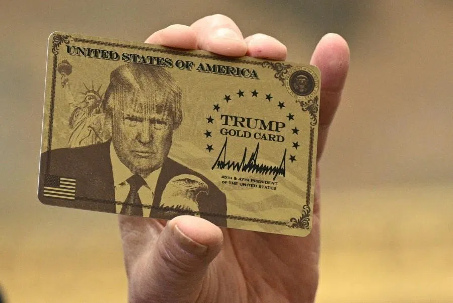US President Donald Trump holds up a “Trump Gold Card” as he makes an announcement from the Roosevelt Room of the White House in Washington, DC, on 19 December 2025. Trump has introduced a $1 million “gold card” residency programme to attract rich immigrants. (Brendan Smialowski/AFP)
