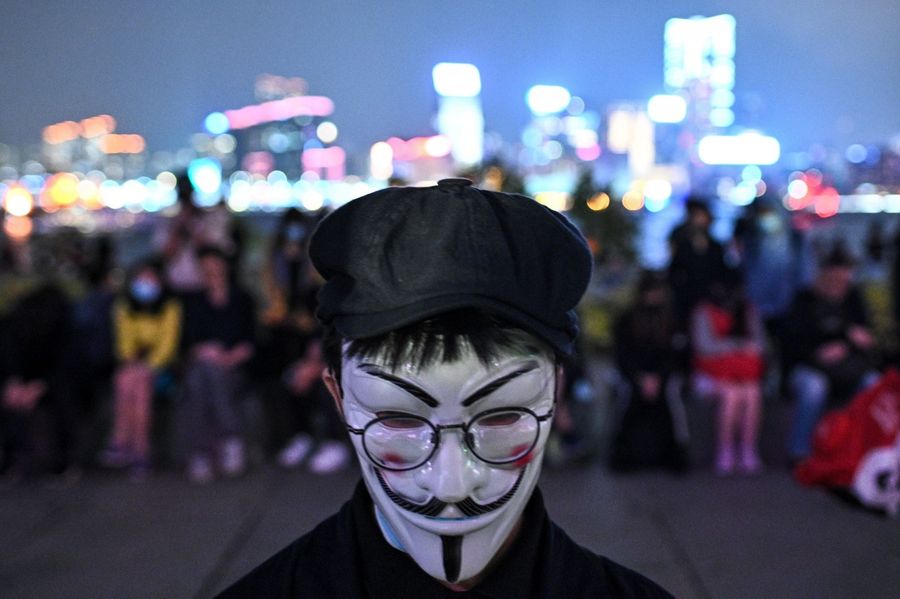A protester wears the Guy Fawkes mask during a prayer rally in Tamar Park in Hong Kong on November 9, 2019, in memory of university student Alex Chow. (Philip Fong/AFP)