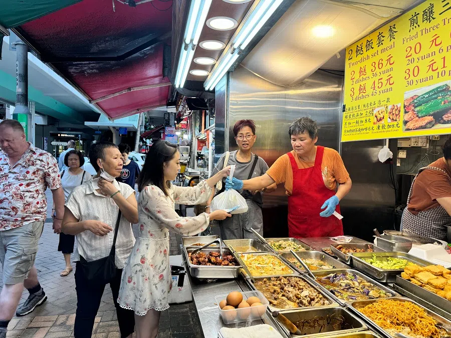Feng Huaying (centre), who works in the media industry in Hong Kong, buys her lunch during the weekdays from a two-dish-rice eatery, July 2024.