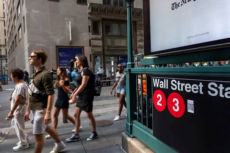 People walk through the financial district by the New York Stock Exchange on 14 August 2024, in New York City. (Spencer Platt/Getty Images via AFP)