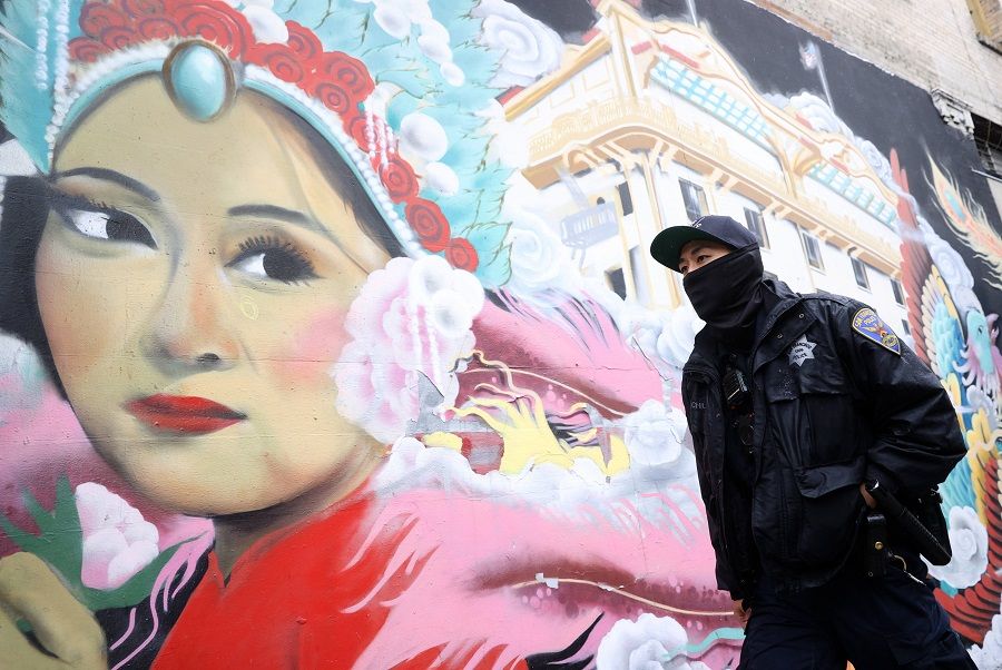 A police officer walks by a mural while on a foot patrol in Chinatown on 18 March 2021 in San Francisco, California. (Justin Sullivan/Getty Images/AFP)
