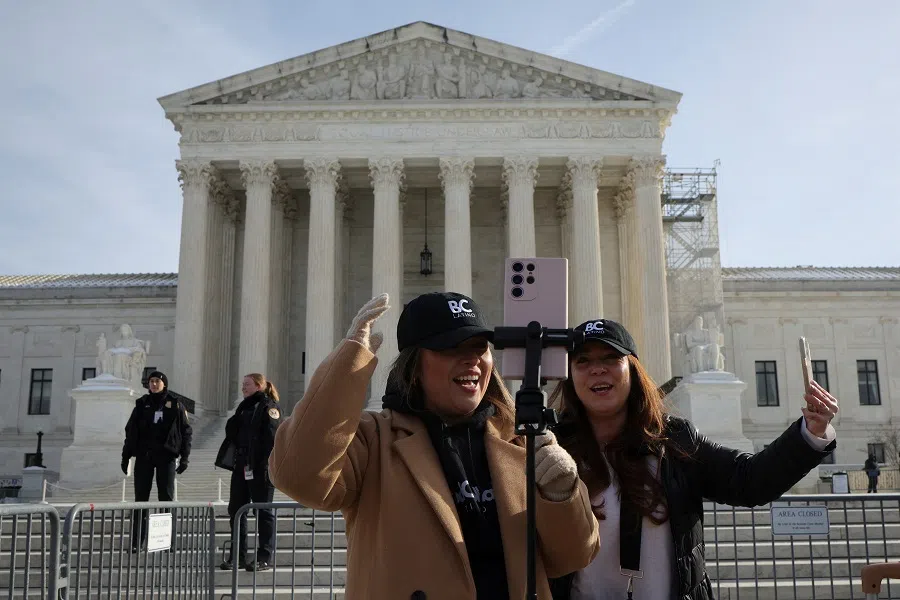 People stream on the day justices hear oral arguments in a bid by TikTok and its China-based parent company, ByteDance, to block a law intended to force the sale of the short-video app by 19 January or face a ban on national security grounds, outside the US Supreme Court, in Washington, US, on 10 January 2025. (Marko Djurica/Reuters)