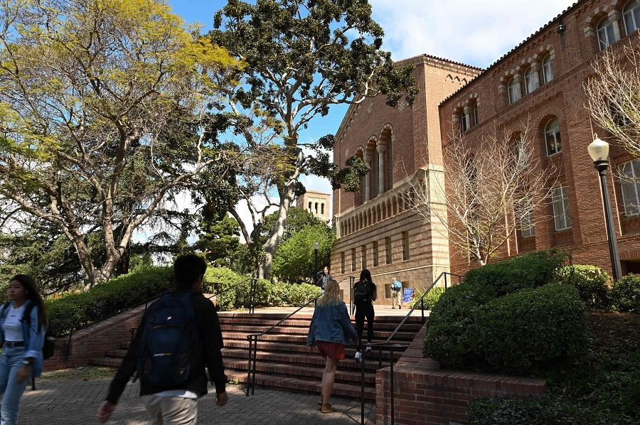 In this file photo taken on 11 March 2020, students walk on the campus of the University of California at Los Angeles in Los Angeles, California, US. (Robyn Beck/AFP)