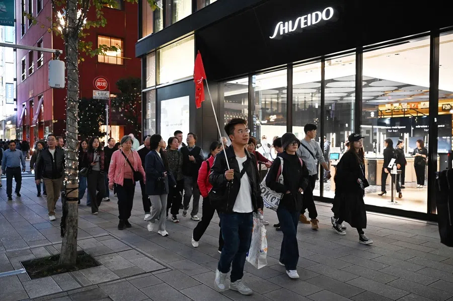 A Chinese tour group walks past a Shiseido store in Tokyo on 17 November 2025.